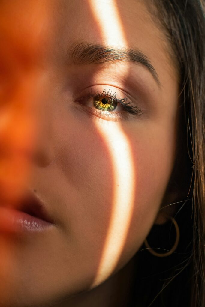 Mujer a la cual le da un rayo de luz en el ojo